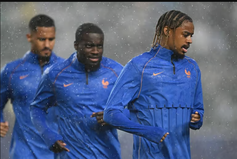 William Saliba, Dayot Upamecano, and Bradley Barcola warmed up in the rain before the match was suspended due to severe thunderstorms.